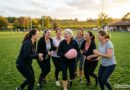 femmes de tous âges riant avec un ballon de rugby en mousse